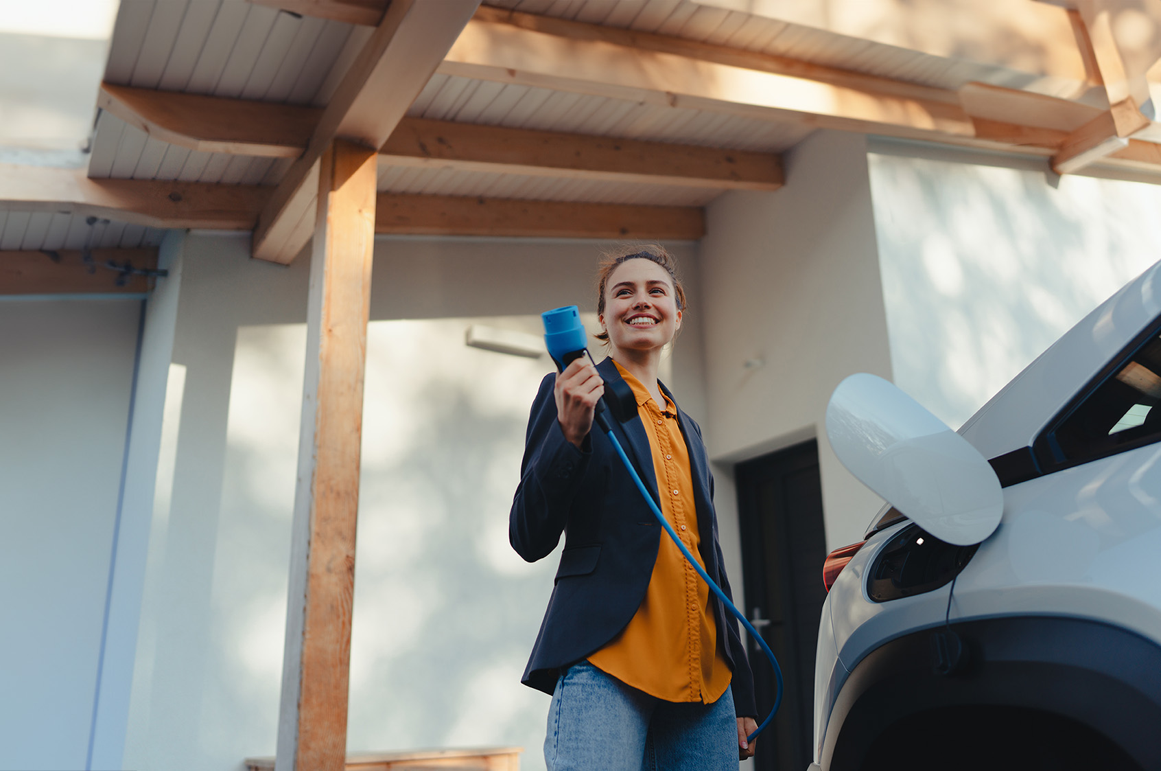 A mother is charging an electric car in the yard.