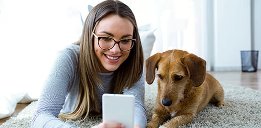 En tilfreds kunde tjekker sine oplysninger via Solteq Utilities Self-Service på sin mobiltelefon eller computer. 