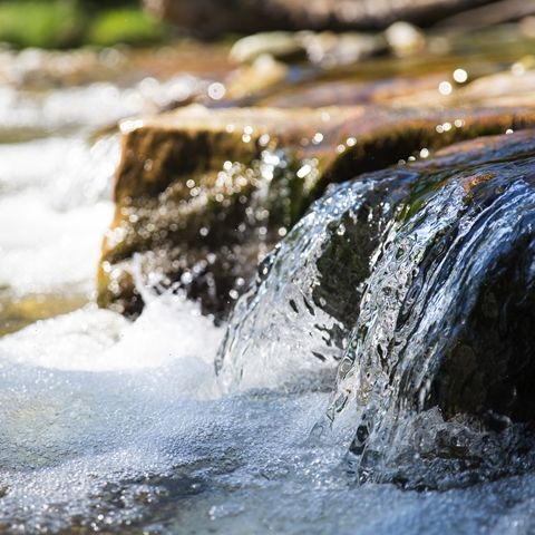 Virtaavaa vettä aurinkoisena päivänä.