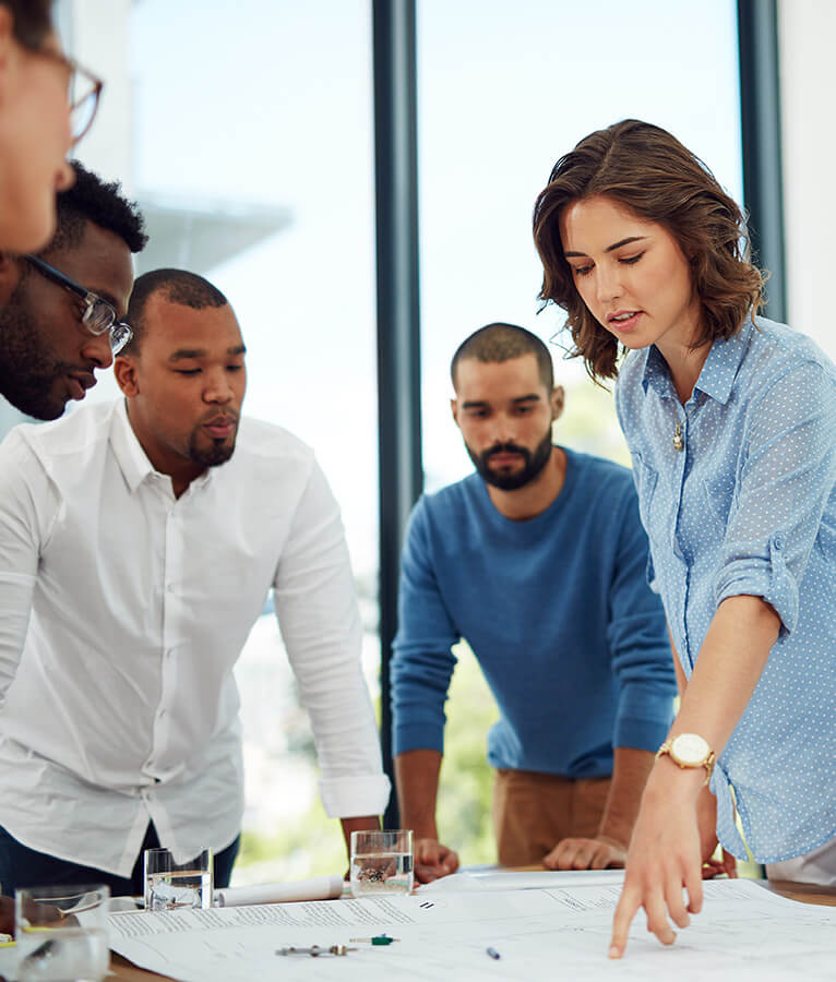 Konsultteja syventyneenä tutkimaan liiketoiminnan kehittämissuunnitelmaa pöydän ympärille.