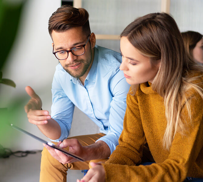 A customer and a consultant engaged in a focused discussion over a tablet.