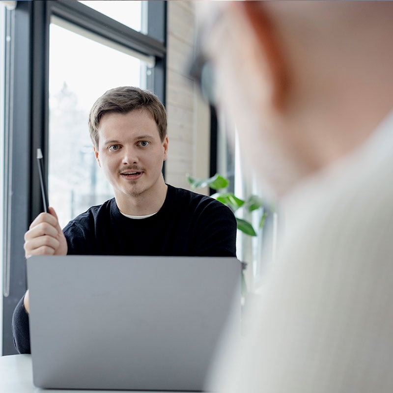 IT experts discuss at the table in front of a computer