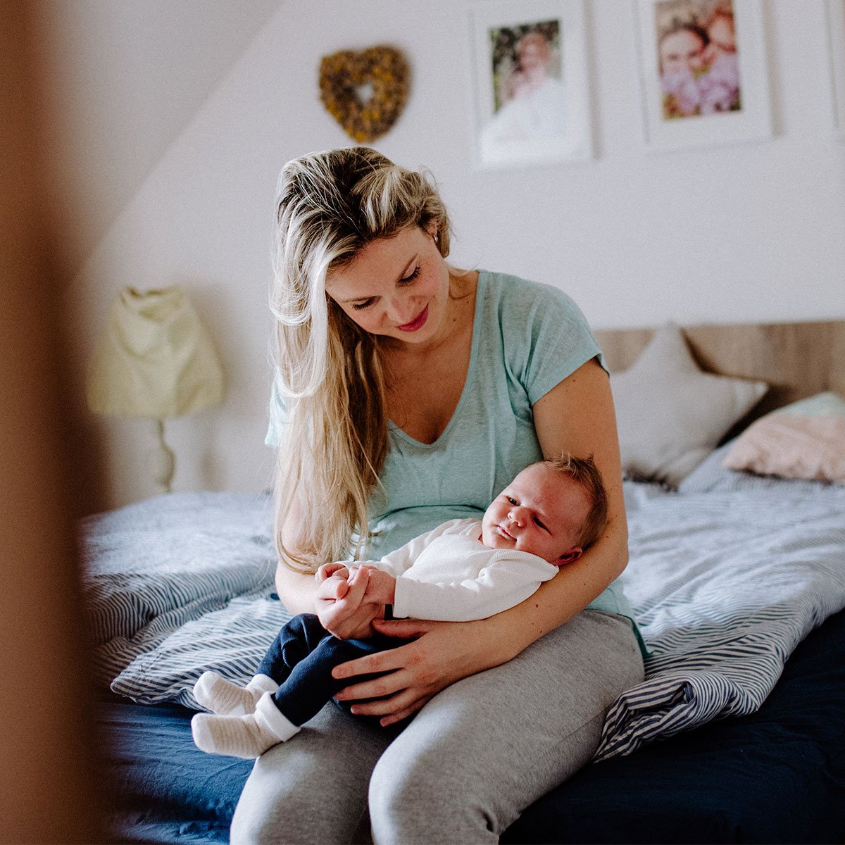 Kvinde i en grøn t-shirt, der holder en baby