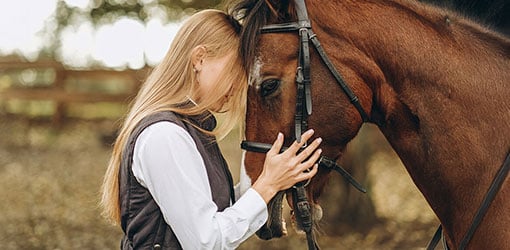 Nainen hevosensa kanssa