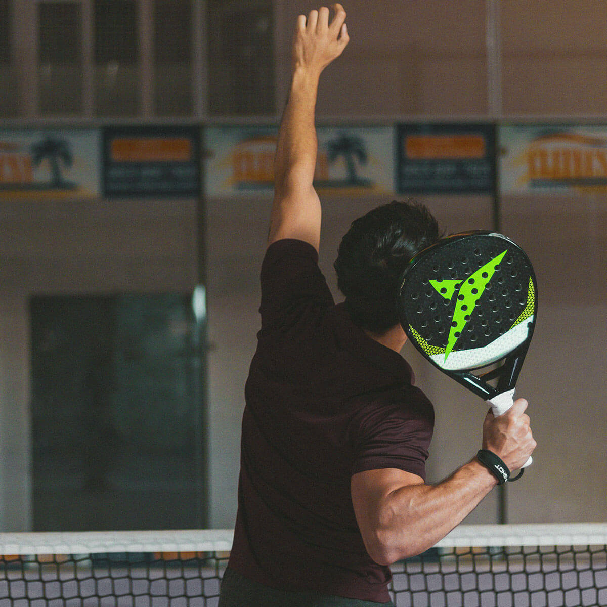 Padelspiller serverer bolden på padelsportsarena