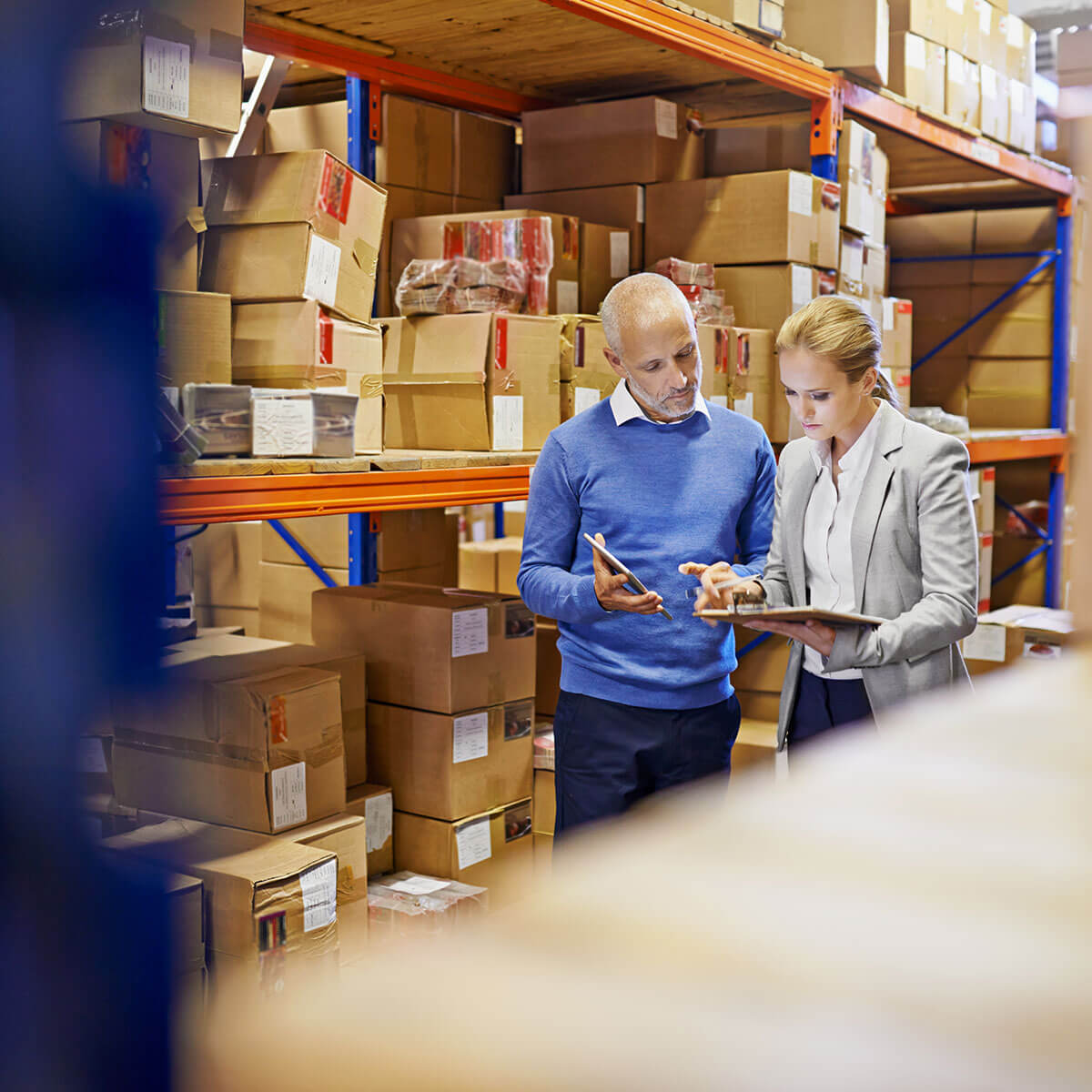 Professionals reviewing warehouse inventory using shared data and connected systems