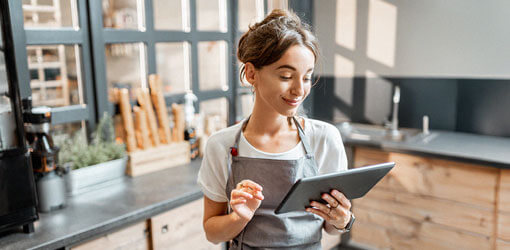 Retailer going through her store sales from point-of-sale system dashboard