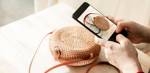 The product information of the bag is searched using the phone's image search.