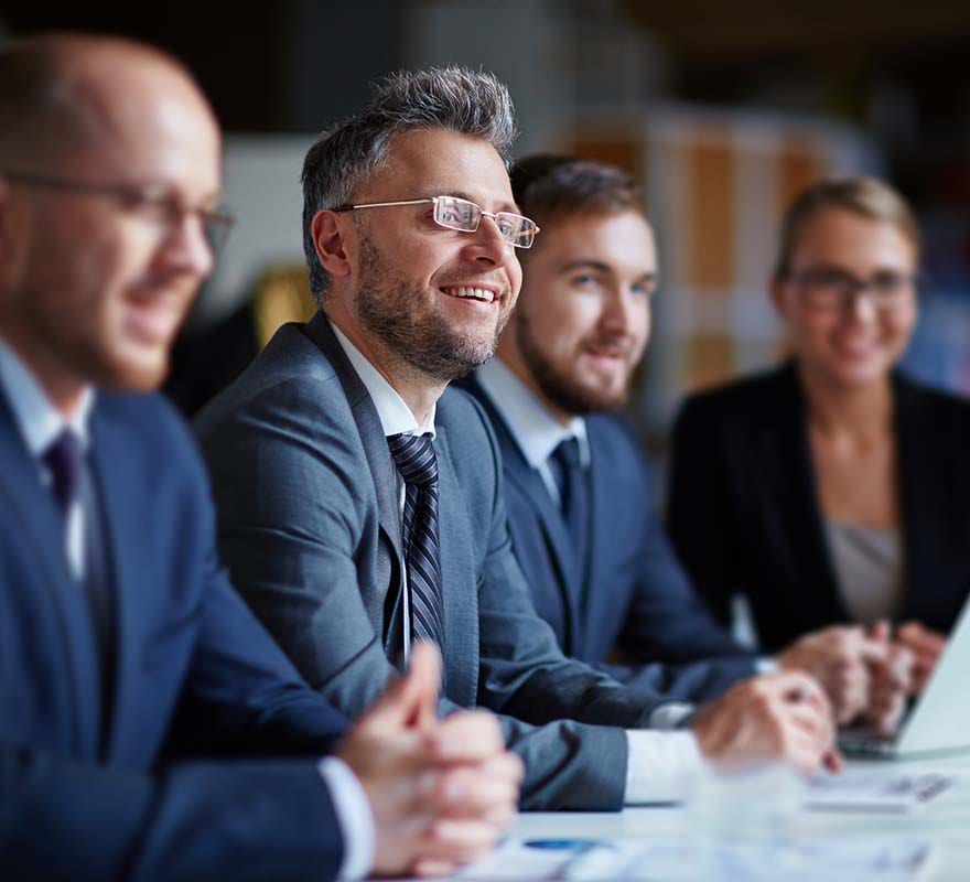 Smiling people around meeting table.