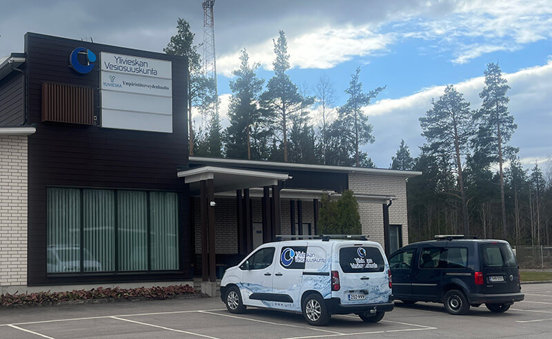 Ylivieskan Vesiosuuskunnan rakennus ja pihan parkkipaikalla olevia autoja.