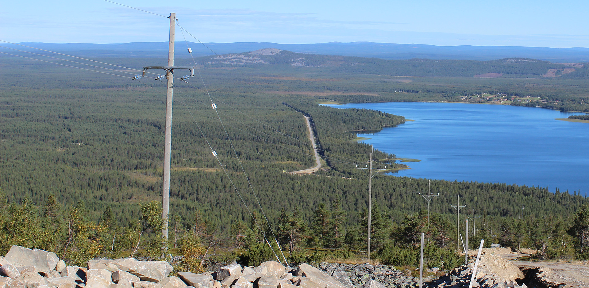Koillis-Lapin Sähkön sähköverkkoa metsäisen mäen päältä Pyhäjärven rannalle (kuva: Koillis-Lapin Sähkö).