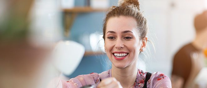 A restaurant employee hands the customer a portion from behind the counter.