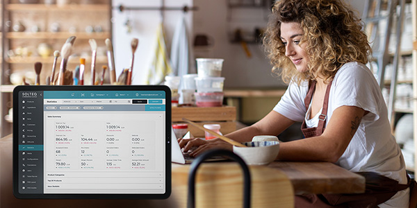 A retailer is examining a sales report on a tablet within the Solteq Commerce Cloud point-of-sale system.