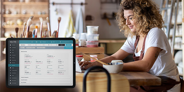 Kauppias tutkii tabletilta myyntiraporttia Solteq Commerce Cloud - kassajärjestelmässä.