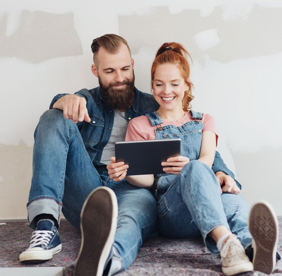 A renovating couple looks at the plan on a tablet