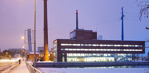 Valaistu Vaasan Sähkön rakennus lumisena talvi-iltana.