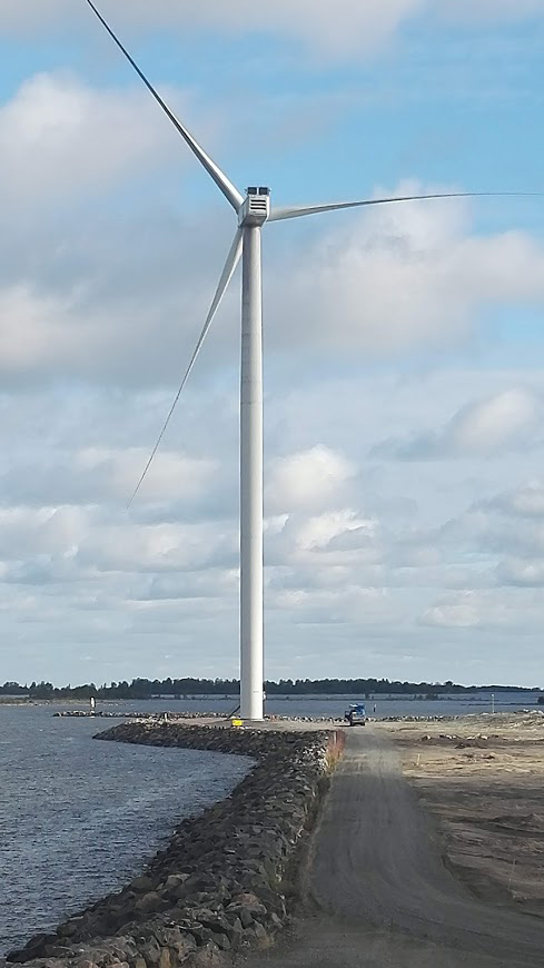 Raahen Energian tuuliturbiini rannalla valkoisia pilvihattaroita vastan,.