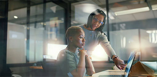 Two woman watching laptop screen and wondering about the value of composable commerce