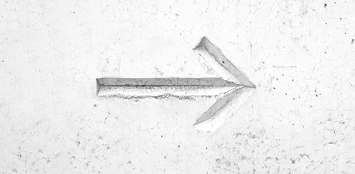 An arrow engraved on a white limestone wall to symbolize the linking of web pages