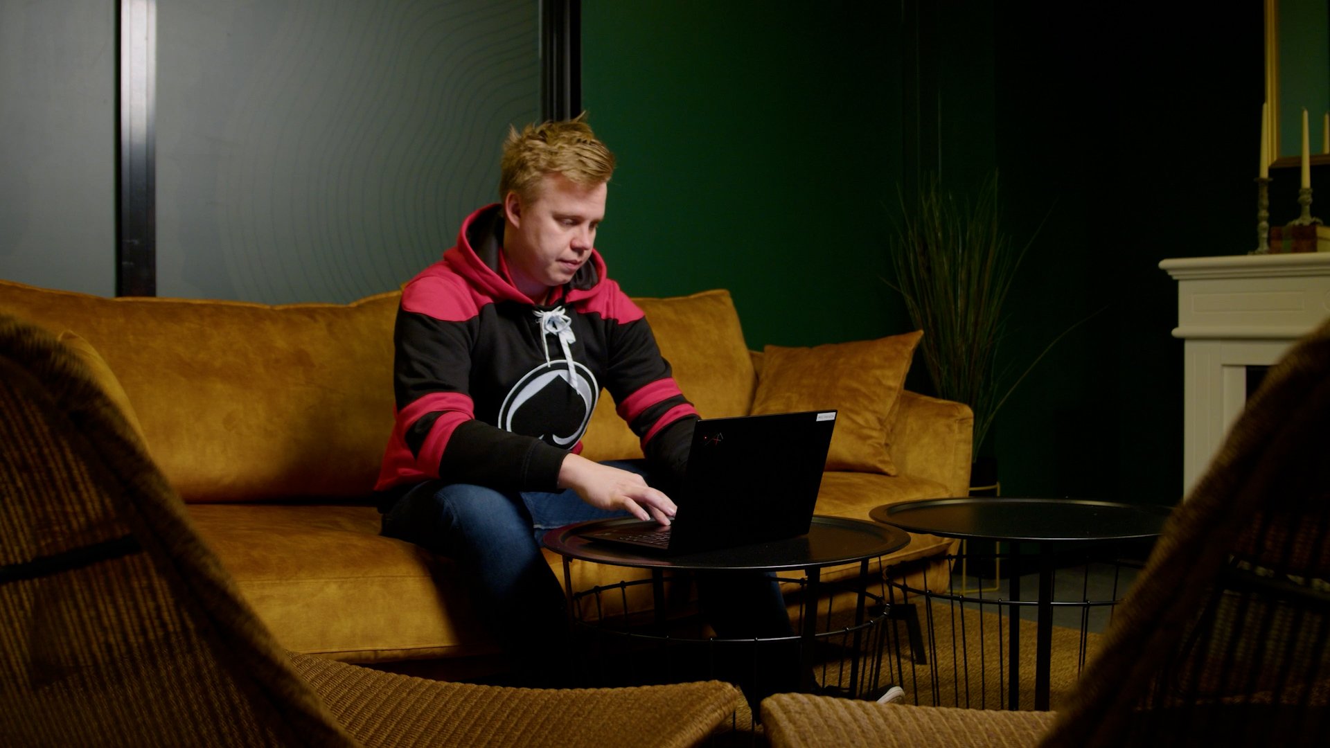 Porin Ässien liiketoimintajohtaja Niklas Ikonen istuu sohvalla ja katsoo tietokoneelta Solteq Commerce Cloud -kassajärjestelmän näkymää.