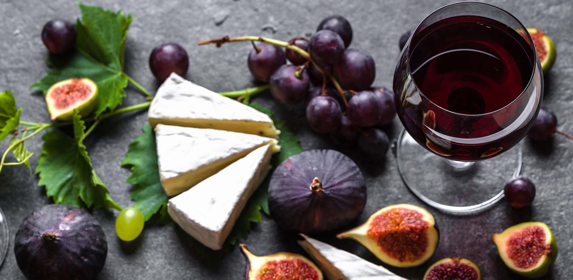 Cheese, wine and figs on the table.