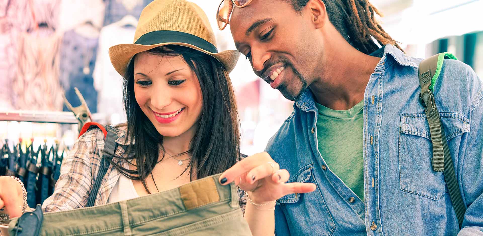 A man and a woman are looking at jeans in a secondhand shop..