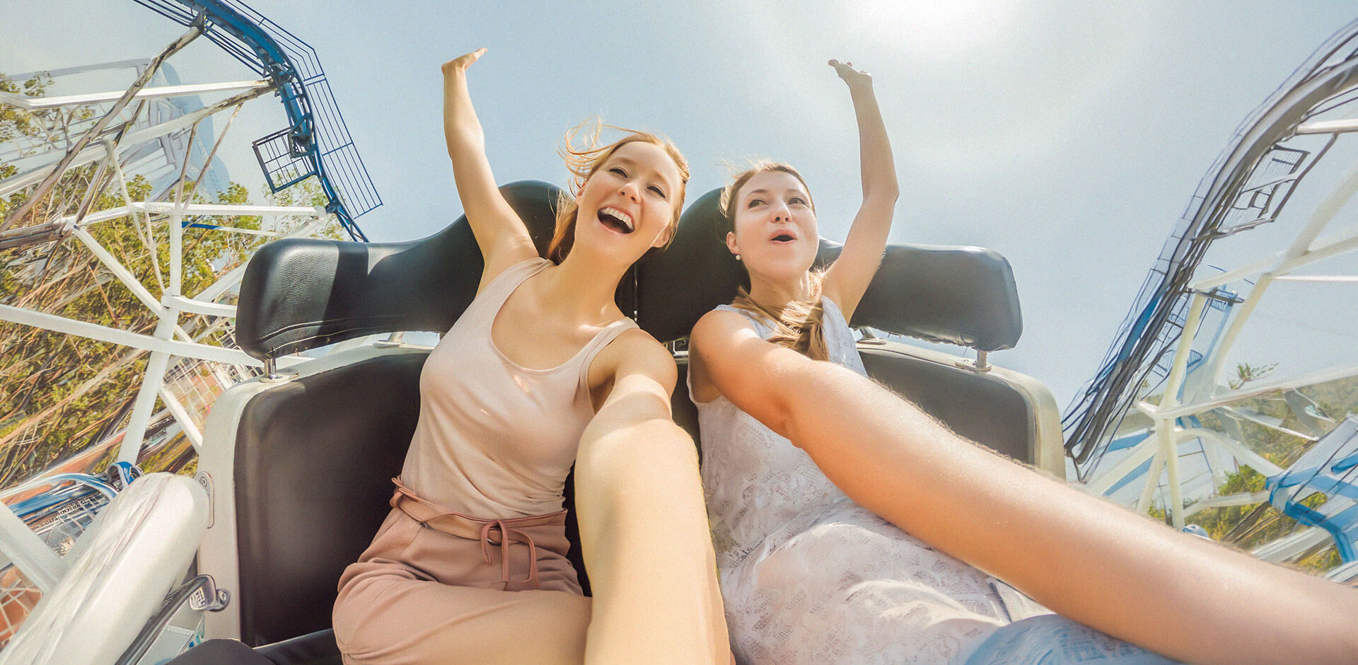 Visitors enjoying a roller coaster ride in a theme park, representing seamless guest experiences supported by modern POS and ticketing systems