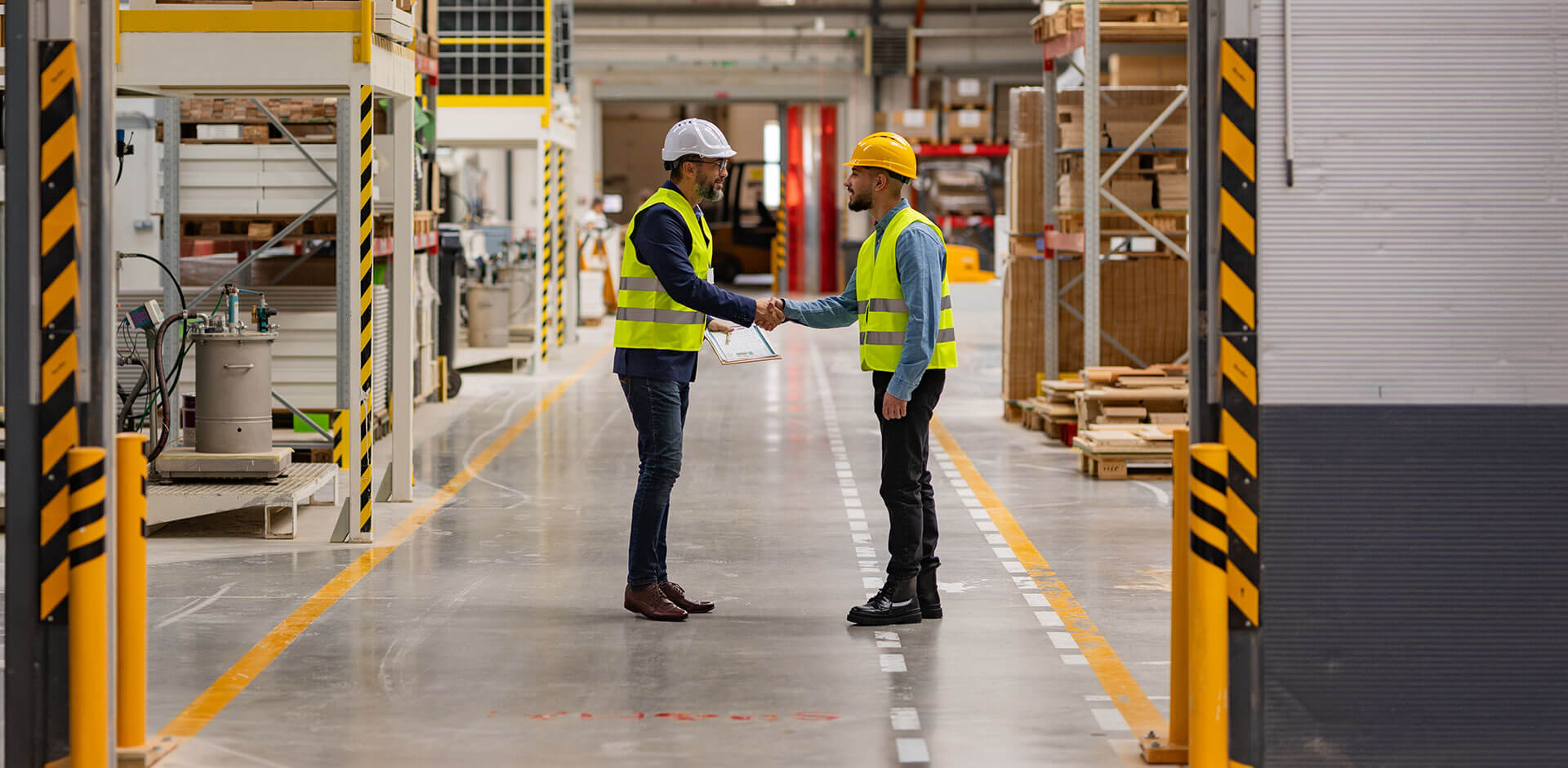 Engineer shaking hands with project manager in modern industrial factory, talking about new manufacturing IT project