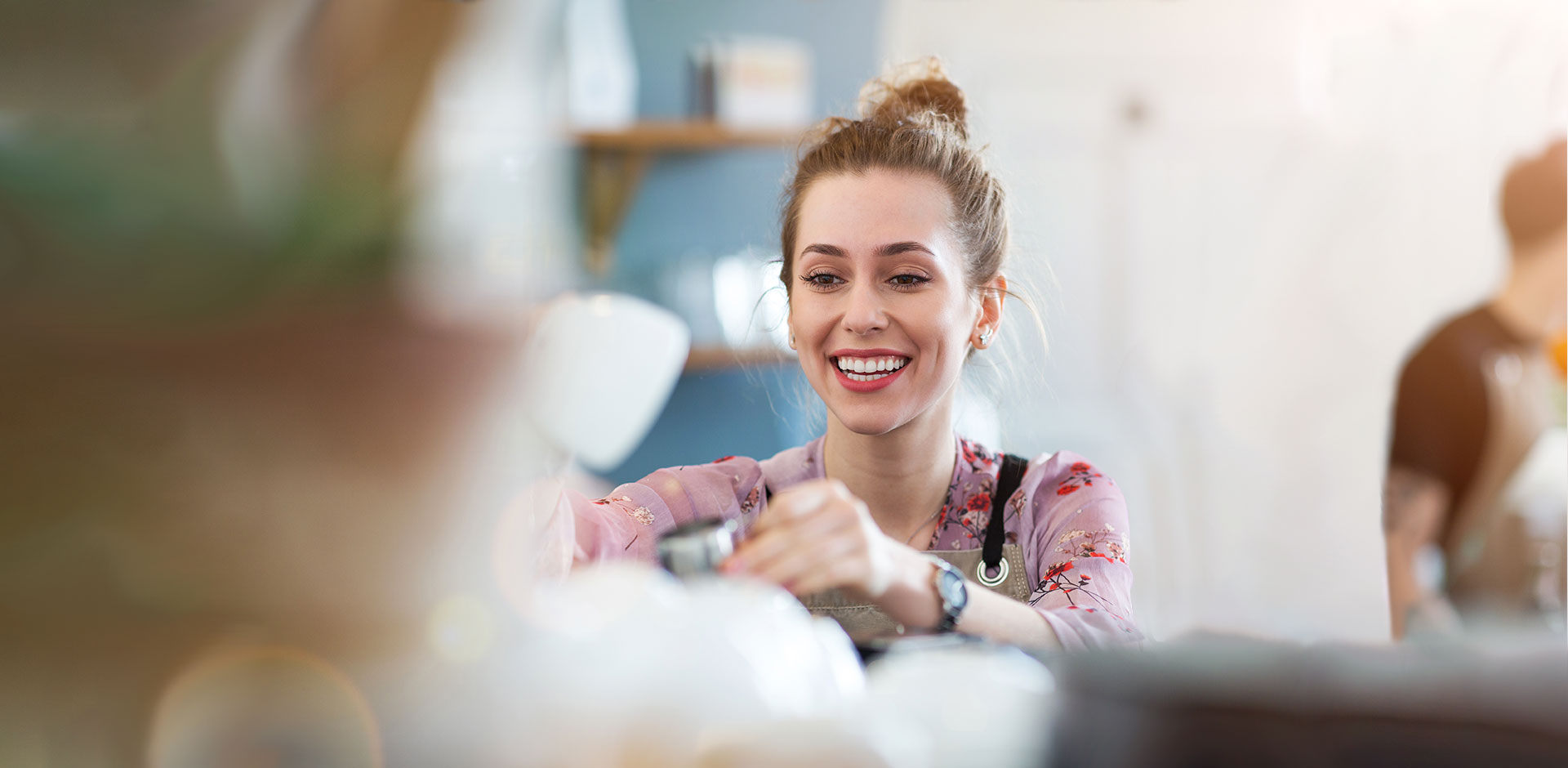 Café worker serving customers in café.