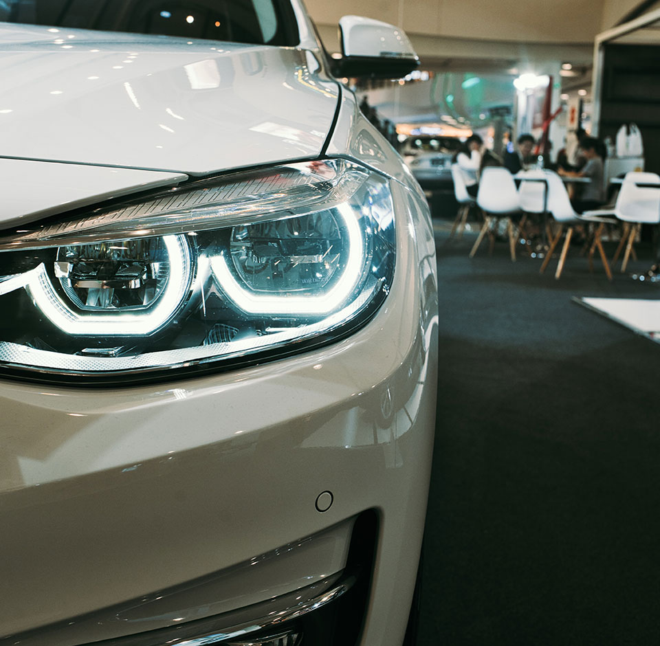 Smart Dealer - Close up of car's headlight in a car dealer showroom