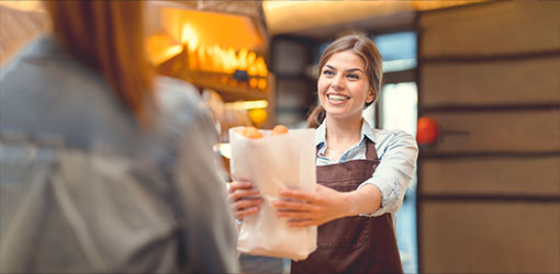 Bakery owner handing out customer purchases