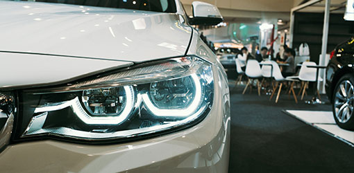 Smart Dealer - Close up of car's headlight in a car dealer showroom