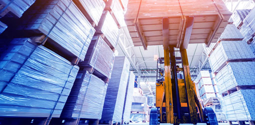 The truck lifts the pallet in a warehouse in a blue tinted image
