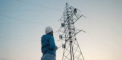 Utility worker looking at power lines