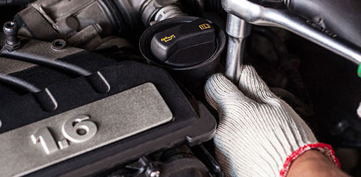 A car mechanic maintaining a car engine.