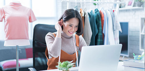 A woman is browsing on a screen in an e-commerce platform in a clothing store.