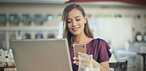 eCommerce - kvinde i en lilla skjorte, der laver e-handel purhaces med mobil