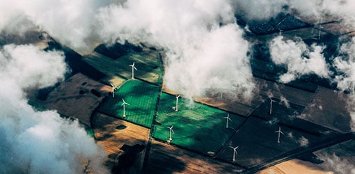 Energia- ja vesitoimialat - Pellolla pyöriviä tuulivoimaloita kuvattuna ilmasta