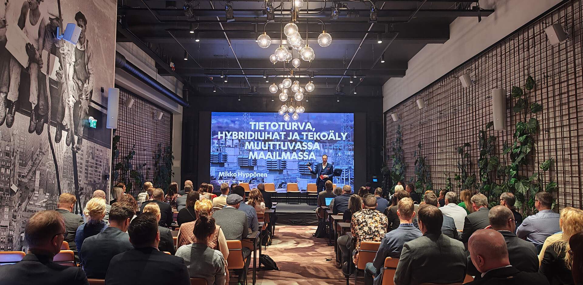 Kuva vuoden 2023 asiakaspäiviltä Hotel Mestarin Leka-juhlasalissa. Lavalla Mikko Hyppönen.