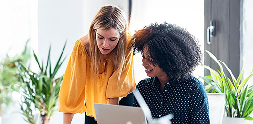 Smiling customer service representatives review customer data in the easy-to-use Solteq Utility Cloud customer information system.